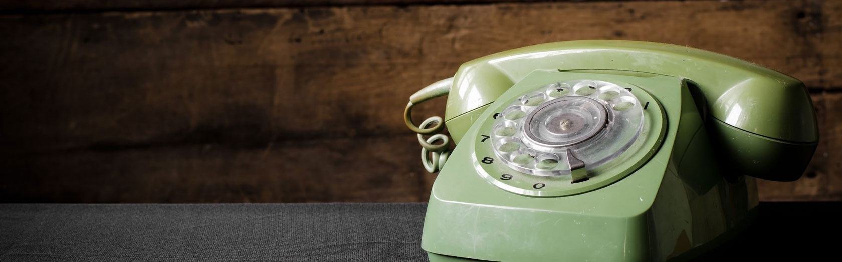 old green phone with wood background